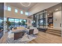 Open living room with high ceilings, modern furniture, and a glass wine cellar feature at 7 Penn Cross Ct, Henderson, NV 89052