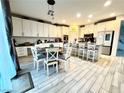 Bright kitchen with white cabinets, an island with seating, and stainless steel appliances at 7245 Blooming Jasmine Ave, Las Vegas, NV 89117