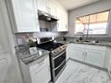 Modern kitchen with white cabinets, granite countertops and stainless steel appliances at 3136 Van Der Meer St, North Las Vegas, NV 89030