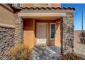 Front entrance with stone pillars and a light beige door at 9210 Piper Down Ave, Las Vegas, NV 89148