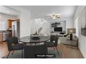 Virtually staged dining room with table and chairs, adjacent to living room at 1018 Maple Pines Ave, North Las Vegas, NV 89081