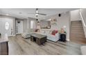 Living room featuring L-shaped sofa and wood-look flooring at 10044 Glen Aire Ave, Las Vegas, NV 89148