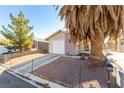 Front view of a house with a palm tree and driveway at 6245 Don Zarembo Ave, Las Vegas, NV 89108