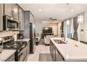 Modern kitchen with island, stainless steel appliances, and gray cabinets at 4537 Cloudrest Peak St, North Las Vegas, NV 89031