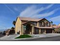 Tan two-story house with tile roof, landscaping, and driveway at 1373 Blazing Sand St, Las Vegas, NV 89110