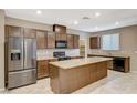 Modern kitchen with island, stainless steel appliances, and dark wood cabinets at 2421 Evening Snow Ct, North Las Vegas, NV 89030