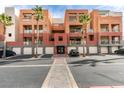 View of the building's exterior with garages and palm trees at 67 E Agate Ave # 202, Las Vegas, NV 89123