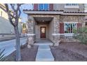 Stone accented front porch with a dark wooden door at 1321 Robbers Roost Ave, Henderson, NV 89012