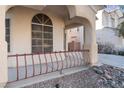 Front porch with wrought iron railing and arched entryway at 7641 Riva Ridge St, Las Vegas, NV 89149