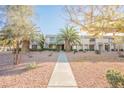 Community view of townhouses with mature palm trees and walkway at 3366 Loma Linda Ln, Las Vegas, NV 89121