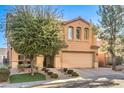 Tan two story house with a two car garage and nicely landscaped yard at 1138 Grove Park St, Henderson, NV 89002