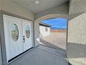 White double front doors with arched entryway and mountain views at 2800 Wisteria Way, Pahrump, NV 89048