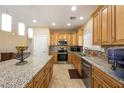 Modern kitchen featuring granite countertops, wood cabinetry, and stainless steel appliances at 4800 Honey Locust Dr, Pahrump, NV 89061