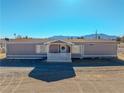 Tan manufactured home with covered porch and mountain views at 3581 W Dyer Rd, Pahrump, NV 89048