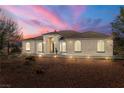 Single-story home with desert landscaping, illuminated at dusk at 3780 Shawnee Ave, Pahrump, NV 89048