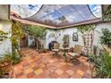 Private courtyard with shade, pavers, charming decor, and lush plants at 2465 El Paseo Cir, Las Vegas, NV 89121