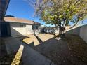 Spacious backyard with a large tree, concrete patio, and privacy walls at 2500 Holly Ave, Las Vegas, NV 89106