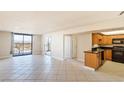 Open living room and kitchen with tile floors and city view at 3930 University Center Dr # 1003, Las Vegas, NV 89119