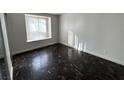 Empty bedroom with dark tile flooring and a large window with blinds at 7300 Pirates Cove Rd # 1065, Las Vegas, NV 89145