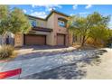 Two-story house with double garage and desert landscaping at 10032 Emerald Pools St, Las Vegas, NV 89178