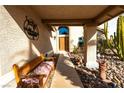 Covered entryway with a wooden bench, decorative rocks, and desert landscaping at 321 Simon Bolivar Dr, Henderson, NV 89014