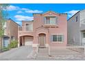 Two-story house with a pink facade, attached garage, and a small front yard at 446 Lime Grass Ave, Las Vegas, NV 89183