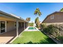 Private backyard with a pool, covered patio, and lush green lawn at 160 Swale Ln, Las Vegas, NV 89144