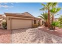 Tan colored house with a two car garage and landscaped yard at 1809 Mountain Ranch Ave, Henderson, NV 89012