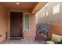 Front entryway with a dark wood door, sidelights, and hanging plants at 2070 Morro Vista Dr, Las Vegas, NV 89135