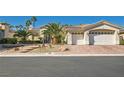 Single-story home with a three-car garage, palm trees, and desert landscaping at 4729 Dream Catcher Ave, Las Vegas, NV 89129