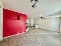 Living room with red accent wall and tile floors at 9488 W Ali Baba Ln, Las Vegas, NV 89148