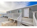 Gray manufactured home with a deck and stairs at 4901 Maple Rd, Pahrump, NV 89048