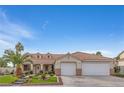 Charming single-story home with a tile roof, three-car garage, and well-maintained landscaping at 1117 Stable Glen Dr, North Las Vegas, NV 89031