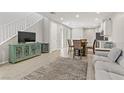 Open living room with gray sofa and view into kitchen area at 542 Celebratory Pl, Henderson, NV 89011