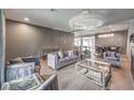 Open concept living area featuring velvet furniture, a fireplace, and a statement chandelier at 5989 Rockway Glen Ave, Las Vegas, NV 89141