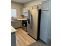 Updated kitchen featuring stainless steel appliances, gray shaker cabinets, and wood-style flooring at 2291 W Horizon Ridge Pkwy # 5228, Henderson, NV 89052