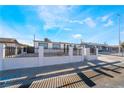 White stucco single-story home with a fenced front yard and paved driveway at 6425 Evergreen Ave, Las Vegas, NV 89107