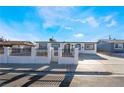 White stucco single-story home with a fenced front yard and paved driveway at 6425 Evergreen Ave, Las Vegas, NV 89107