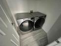 Laundry room with front-loading washer and dryer, white door and tiled floor at 4828 Storm Mountain St, Las Vegas, NV 89130