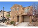 Two-story home with balcony, attached garage, and desert landscaping at 499 Warminster Ave, Las Vegas, NV 89178