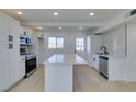 Modern kitchen featuring white shaker cabinets, quartz countertops, and stainless steel appliances at 704 Stanford St, Las Vegas, NV 89107