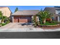 Two-story house with a two-car garage and palm trees in the front yard at 10042 Pipestone St, Las Vegas, NV 89141