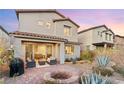 Landscaped backyard with patio, fire pit, and access to the house at 23 Papavero Ct, Henderson, NV 89011