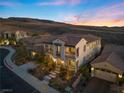 Two-story house with tile roof, stone accents, and a landscaped yard at sunset at 2381 Luberon Dr, Henderson, NV 89044