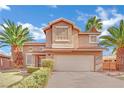 Beige two-story house with a two-car garage and landscaping at 4250 Lael Ct, North Las Vegas, NV 89032