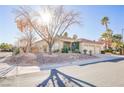 Single-story home with a three-car garage, landscaping, and a decorative wreath at 10201 Los Padres Pl, Las Vegas, NV 89134