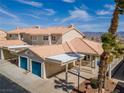 Aerial view of a two-story home with a tile roof, attached two-car garage, and palm trees at 2160 Camel Mesa Dr, Laughlin, NV 89029