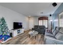 Bright living room with hardwood floors, comfy seating, and a Christmas tree at 7686 Silent Falls St, Las Vegas, NV 89123