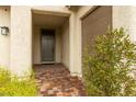 Front entry with gray door and brick paver walkway at 6524 Summershade St, North Las Vegas, NV 89086