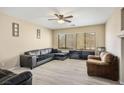 Living room with a sectional sofa, two armchairs, and wood-look flooring at 540 Civic Holiday Ave, North Las Vegas, NV 89031